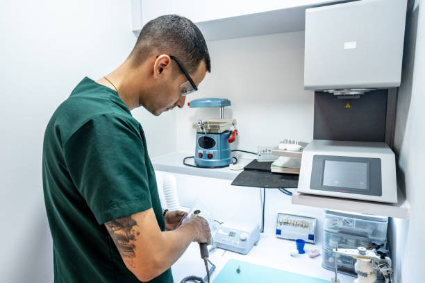 istock Dental assistant/technician using a mini saw to cut a denture mold at dentistry laboratory 1491990168