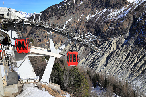 One red Swiss funicular from Sierre to Crans Montana, Valais Canton, Switzerland. Public transport cable car with scenic view over Sierre city and mountain.