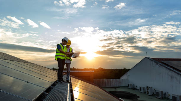 istock Engineer working setup Solar panel at the roof top. Engineer or worker work on solar panels or solar cells on the roof of business building 1491997195