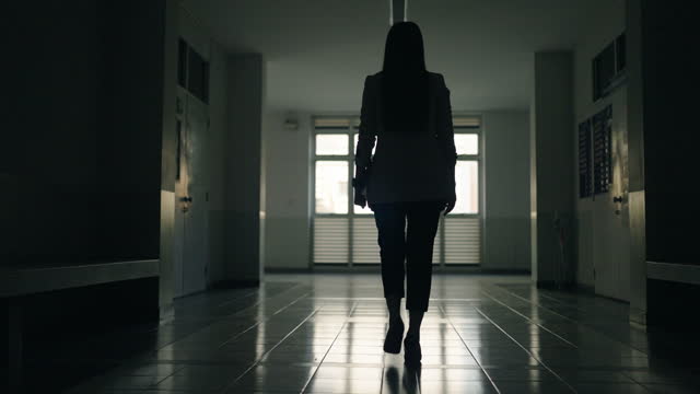 businesswoman walk walk towards the exit door silhouette night dark in office