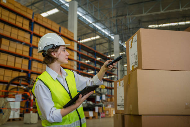 istock Worker scanning parcels for retail and transport shipping in warehouse stock checking. 1491999534