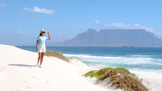 Bloubergstrand Cape Town South Africa on a bright summer day, Blouberg beach, with powder-soft white sand, and blue ocean. women chilling on the beach