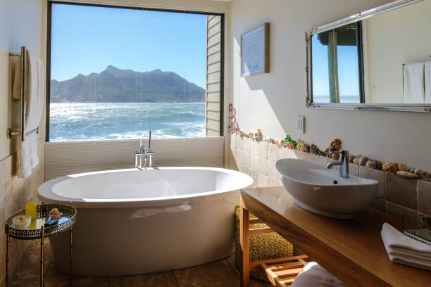 bathtub looking out over the ocean of Cape Town South Africa during vacation. Bath Tub during sunset bathtub looking out over the ocean of Cape Town South Africa during vacation. Bath Tub during sunset, hot tub on vacation coastal bathroom stock pictures, royalty-free photos & images