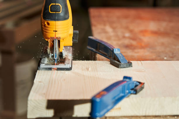 istock a board fixed with clamps is sawed by an electric jigsaw along a laser marker. sawdust scatter in different directions 1492009490