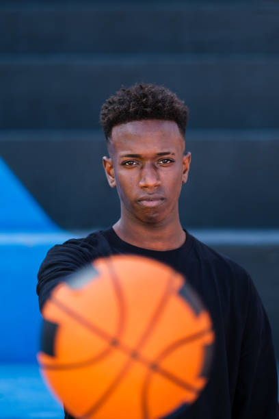 istock Young man holding a basketball on colorful background 1492014897