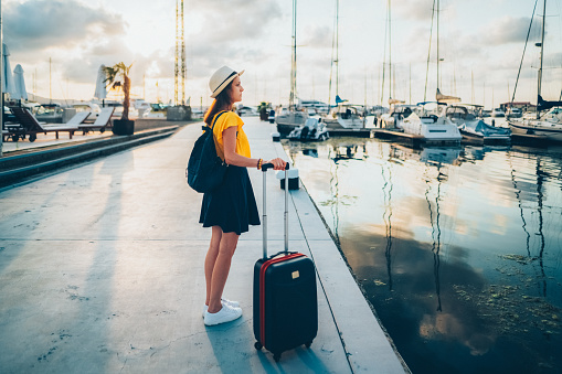 Tourist woman staring at the yachts before boarding