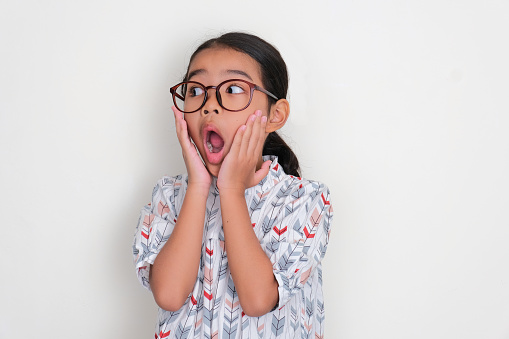 Asian little kid showing shocked face expression when looking to the right side