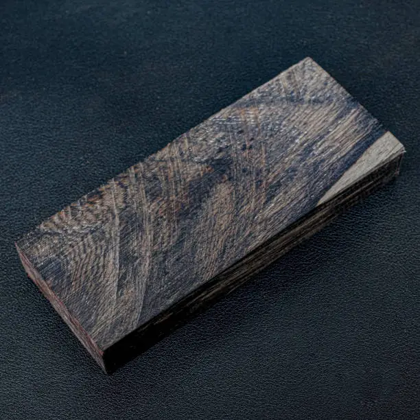 Sawn timber of rare Ebony wood with a beautiful pattern for crafts on black background