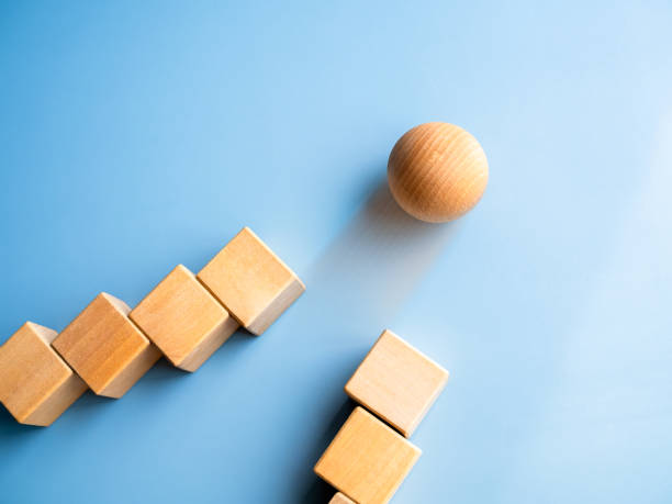 istock Wooden sphere rolling leading at front, following with wood cube blocks on blue background. Leadership, business success, unique, difference, challenge, and motivation concepts. 1492022223