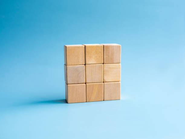 istock Nine empty simple wooden puzzles stacking arranging compleated isolated on blue background, minimal style. Solution, solve problem, business goal and success plan concepts. 1492022319