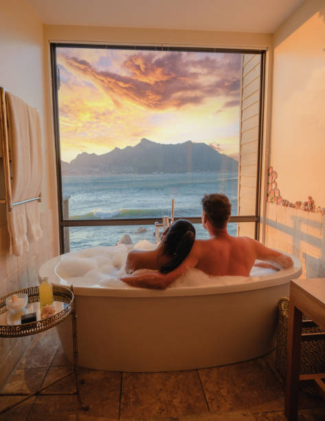 casal em uma banheira com vista para o oceano da cidade do cabo áfrica do sul durante as férias - couple hot tub spa treatment health spa - fotografias e filmes do acervo