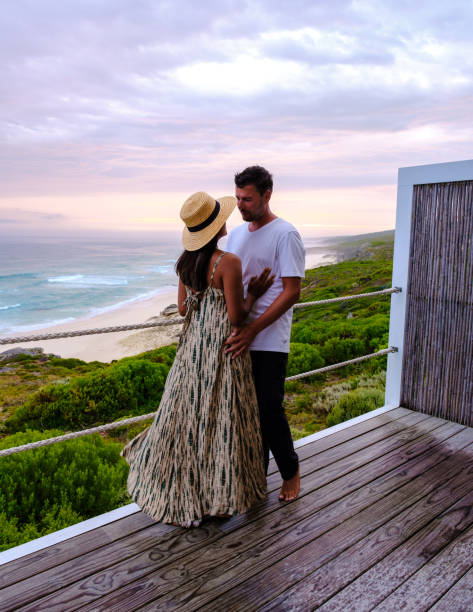 a couple of men and women watching Sunset at De Hoop Nature reserve South Africa Western Cape A couple of men and women watching the sunset at De Hoop Nature Reserve South Africa Western Cape, a beautiful beach in South Africa with the white dunes at the de hoop nature reserve garden route. couple hope sky blue stock pictures, royalty-free photos & images