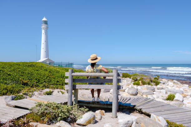 women visiting the lighthouse of Slangkop Kommetjie Cape Town South Africa women visiting the lighthouse of Slangkop Kommetjie Cape Town South Africa, The Slangkop lighthouse in the village of Kommetjie on the Cape Town Peninsula. kommetjie stock pictures, royalty-free photos & images