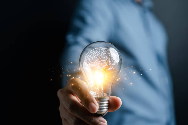 istock Hand man holding illuminated lightbulb, idea, innovation and inspiration with glowing virtual brain, smart intelligent creativity with bulbs, Motivation and innovation concept 1492025359