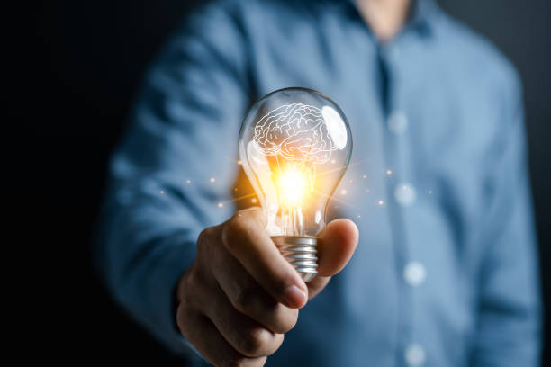 istock Hand man holding illuminated lightbulb, idea, innovation and inspiration with glowing virtual brain, smart intelligent creativity with bulbs, Motivation and innovation concept 1492025481