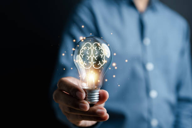 istock Hand man holding illuminated lightbulb, idea, innovation and inspiration with glowing virtual brain, smart intelligent creativity with bulbs, Motivation and innovation concept 1492025487