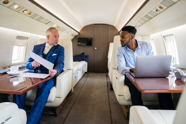 istock Businessmen discussing report during private jet flight 1492025810