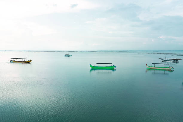 Traditional fishing boats anchored on the beach on a cloudy afternoon