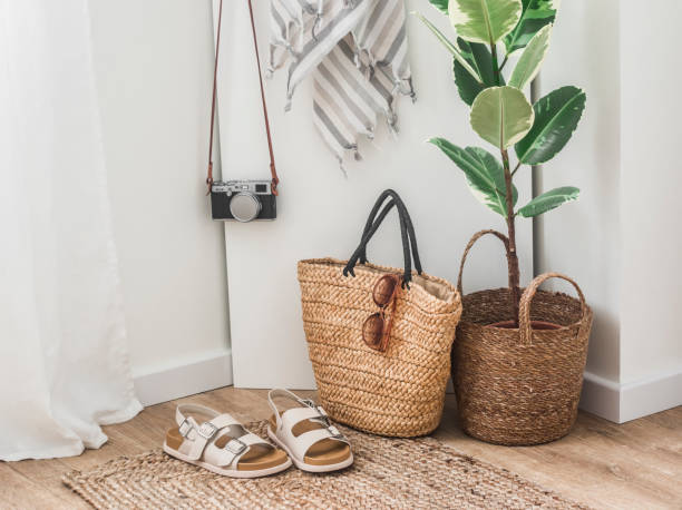 Vacation concept. Straw bag, comfortable sandals, beach towel, camera in a cozy bright room