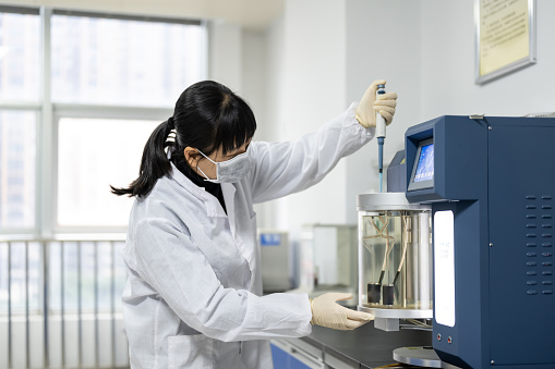 A female technician is using instruments in the laboratory for industrial chemistry testing