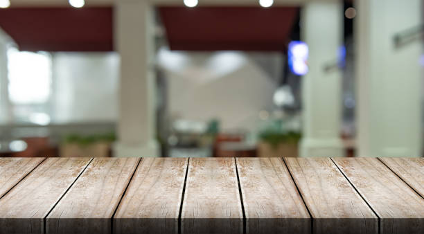 istock Empty wooden table top with lights bokeh on blur restaurant background. 1492039443