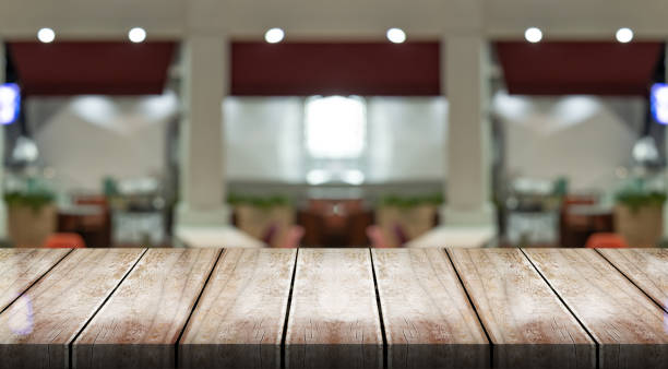 istock Empty wooden table top with lights bokeh on blur restaurant background. 1492039445