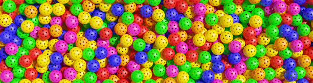 istock Pickleball banner. Many multi-colored sports balls. 3D rendering 1492041468