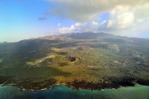 Grande Comore / Ngazidja, Comoros islands: view from above the north coast with the Ouemani / Wemani crater in the foreground and at the top, Mount Karthala (2361m), a very active  shield volcano, the highest point in Comoro Islands, and one of the largest craters in the world. Multiple cinder cones in between. Grande Comore is geologically the youngest island in the archipelago. Agriculture is hardly possible there because of lave fields and the lack of fresh water sources. Coelacanths live on the island's sea slopes, for which a marine reserve has been created with the Zone du Coelacanthe .
