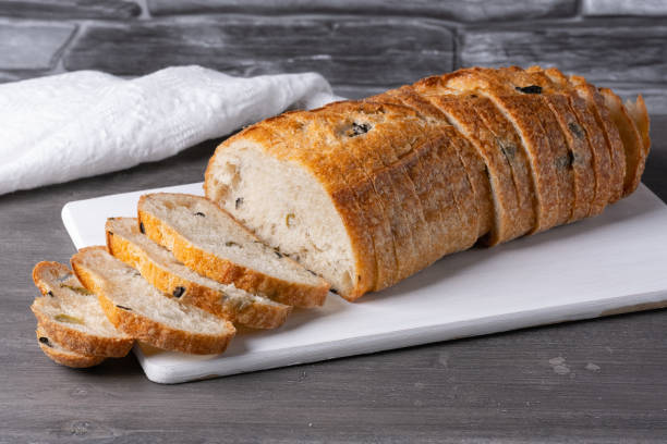 istock Bread with olives on a white cutting board on a gray table 1492047503