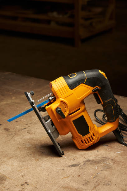 istock a black and yellow jigsaw in working readiness with a blue cutting file installed stands on a wooden workbench 1492049598