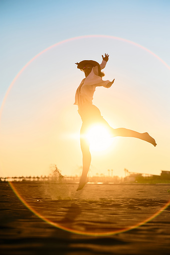 Playful woman having fun while dancing on sunset in summer day. Copy space.