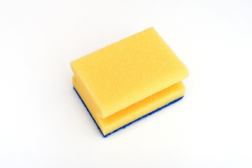 Cleaning sponge on the wood background with copy space