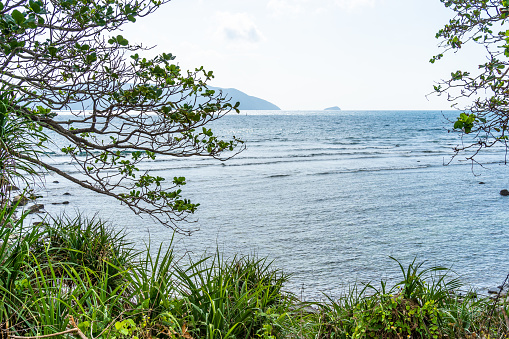 a peaceful Con Dao island, Vietnam is a Vietnamese island heaven. Coastal view with waves, coastline, clear sky and road, blue sea, tourists and mountain. Travel and landscape concept.