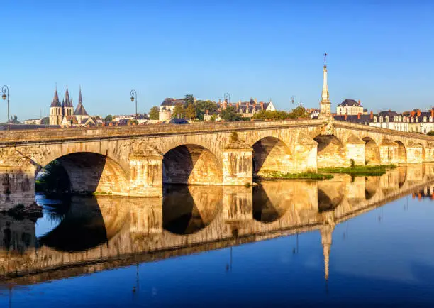 Old bridge in Blois, France, Europe. Scenery of vintage stone structure over Loire River, historical landmark of Blois city. Theme of travel and summer vacation in Blois town.