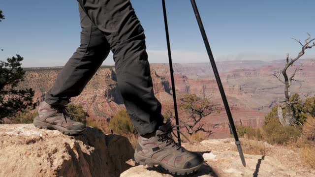 Feet Of Tourist Walking To Top Of Canyon Mountain On Stones Making Big Steps