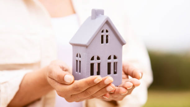 Small toy house in hands stock photo
