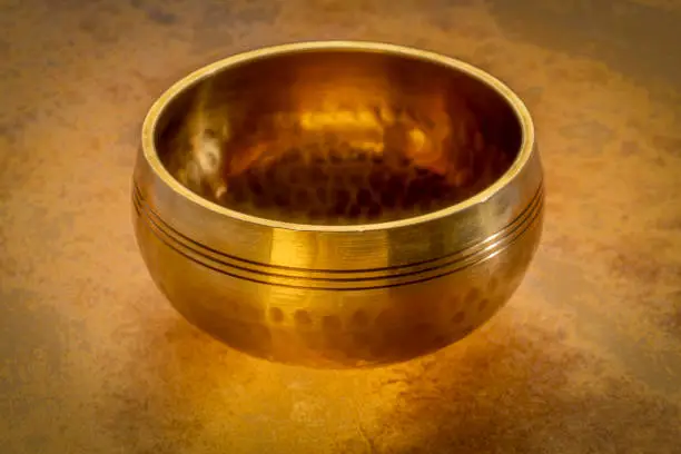 tibetan singing bowl on a backlit leather surface, sound therapy for healing, relaxation and meditation