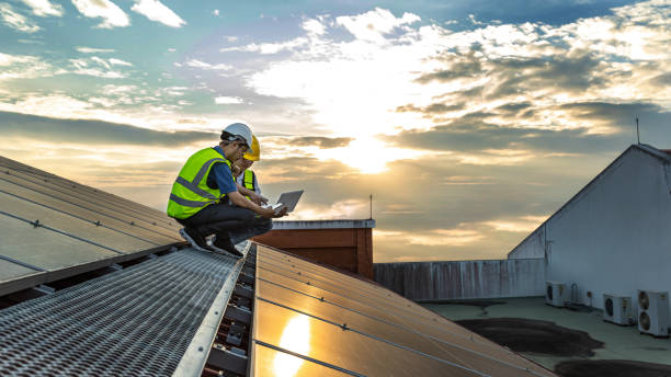 istock Engineer working setup Solar panel at the roof top. Engineer or worker work on solar panels or solar cells on the roof of business building 1492067261