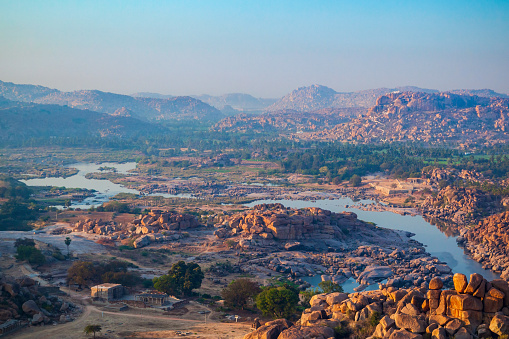 Mountain with boulders and river at Hampi, the centre of the Hindu Vijayanagara Empire in Karnataka state in India