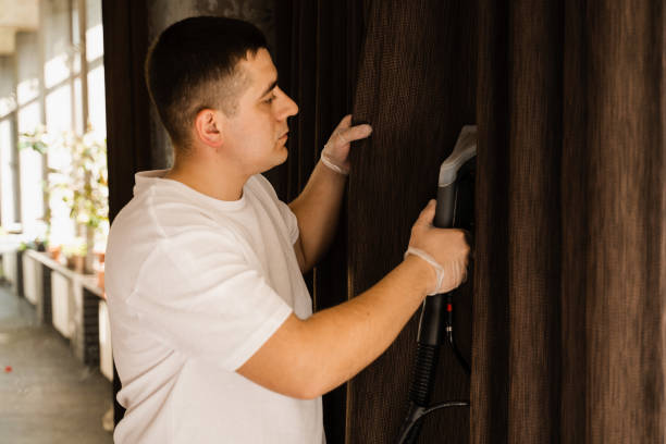 istock Dry cleaning of curtains using extraction method in professional cleaning service. Cleaning curtains with extractor machine. Process of extracting dirt and dust from curtains. 1492071591
