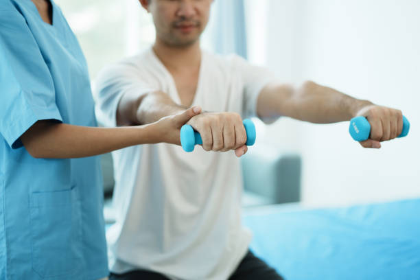 physiotherapist treating rehabilitation arm pain patient doing physical therapy exercises. - outpatient imagens e fotografias de stock