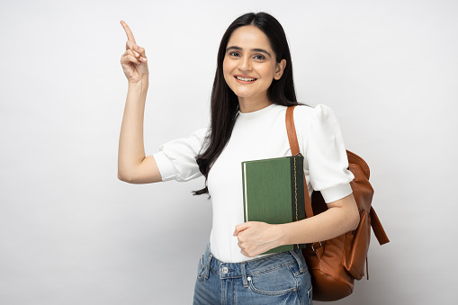 Portrait of happy female student standing on white background