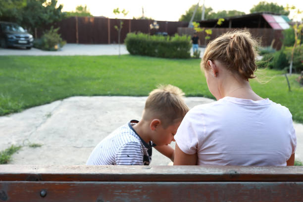 istock Mother with her son sitting on bench 1492078467