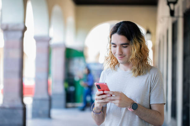 istock Gay male using cell phone outdoors 1492082284