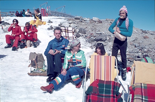 Austria (exact location unknown), 1978. Winter vacationers sitting in the sun at the edge of a ski slope in the European Alps.
