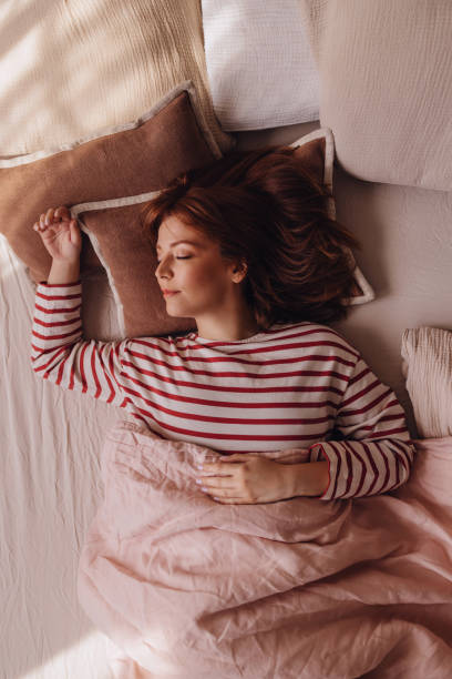 침대에 누워 주말에 자고 있는 아름다운 생강 여자 - red bed 뉴스 사진 이미지