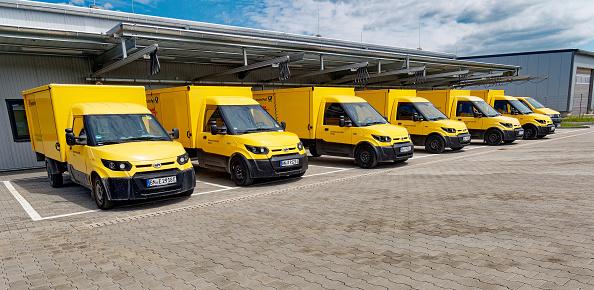Markt Bibart, Germany - The Deutsche Post electric vans called Streetscooter are standing at a charging station on a cloudy day. The small transporter with electric drive is designed for city traffic.