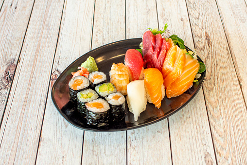 Assorted sushi platter with maki stuffed with rice and avocado, red tuna nigiri, cooked shrimp, nori seaweed and butterfish, Norwegian salmon sashimi and Mediterranean bluefin tuna