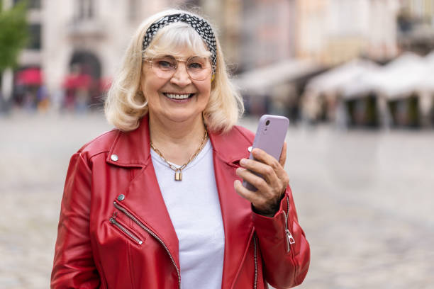 istock Senior woman use smartphone typing text messages browsing internet finishing work looking at camera 1492100347