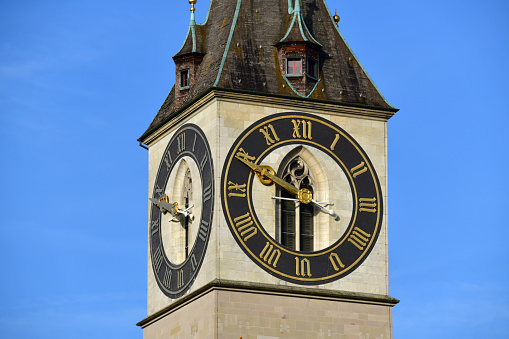 Zurich, Switzerland: clock tower of St. Peter Church, St. one of the three old town churches that characterize the silhouette of Zurich. It is located on a hill in the old town on the left bank near the Lindenhof, where the Roman settlement of Turicum and the imperial palace were located. With a diameter of 8.64 meters, the tower clock has the largest tower clock face in Europe. The black rings are painted directly onto the brickwork, the numerals and the two gold circles are made of two millimeter thick double-gilded copper sheet.